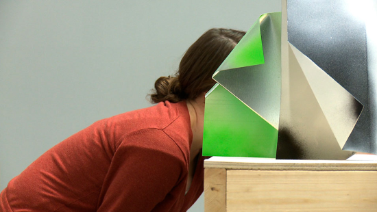 person leaning their face into a box on a table top