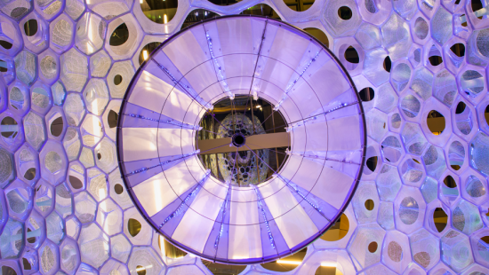A purple circular metal structure with lines and holes.