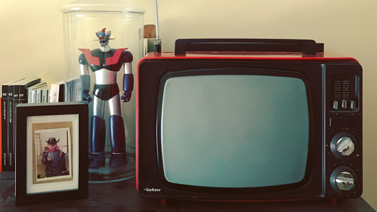 Vintage TV, action figure, and framed photo of a child in costume on a table