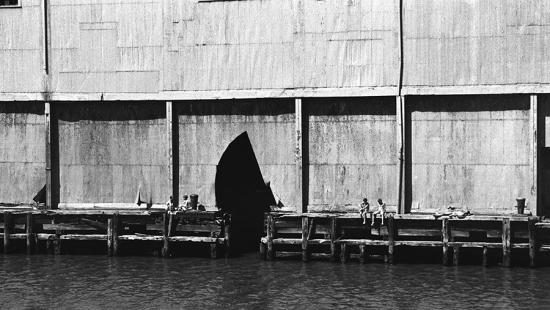 black and white image of people on a pier 