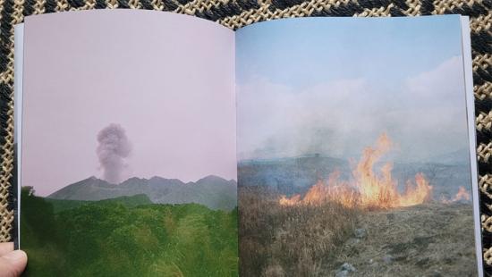 open book showing two images of fires on open landscapes