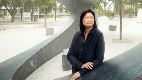 A person wearing black leaning on a memorial.