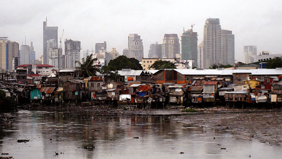 informal settlement with floodwater and manila city scape in the background