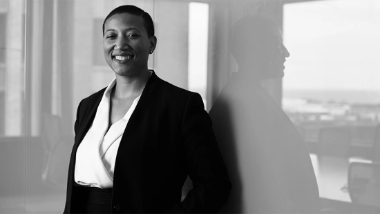 Portrait of a person looking at the camera wearing a white blouse and black jacket.