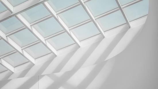 Light comes through mutiple square panes in a skylight.