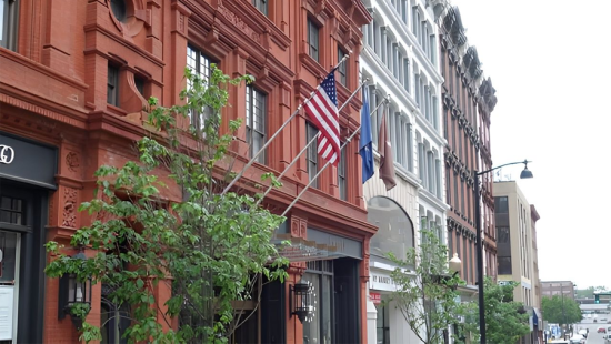 A red building with an American flag and a tree out front.