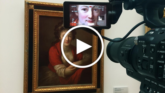 A camera pointed at a painting with a close up shot appearing in the viewfinder screen.
