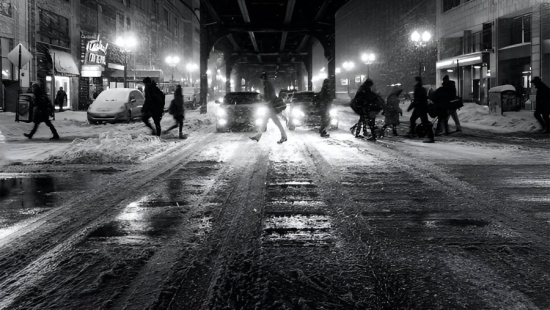 people walking on a city street in the winter at night