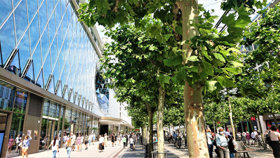 Pedestrians outside a glass shopping complex