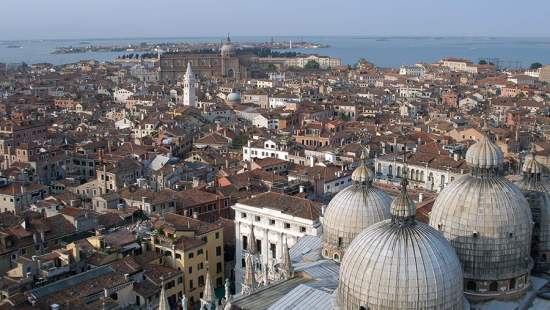 Aerial view of rooftops of Venice with water in the distance