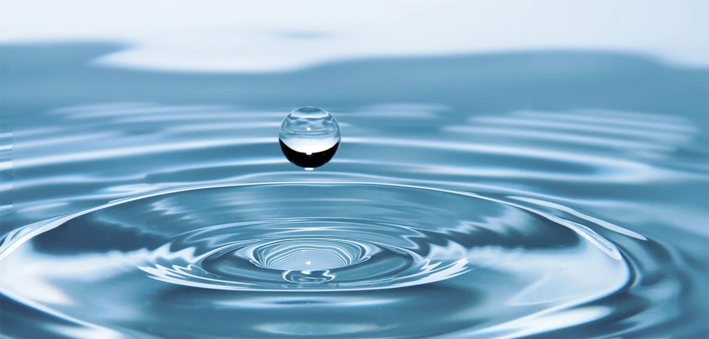 drop of water above the surface of pool of water showing rings on the surface