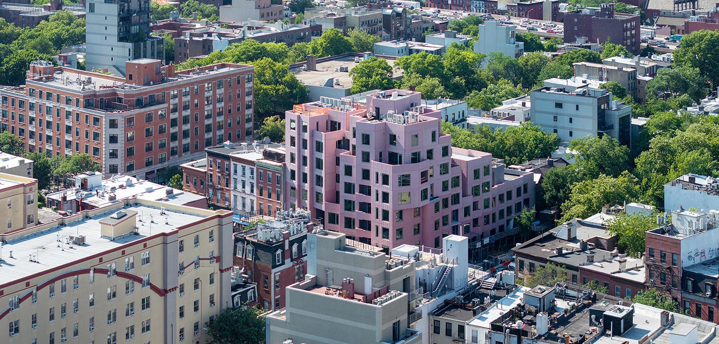 a series of large buildings in a city surrounded by trees.