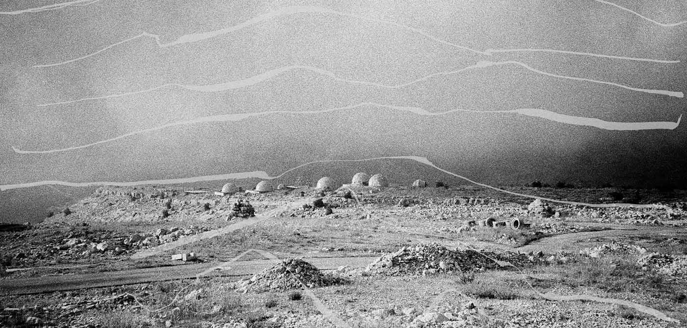 Black and white photograph of a desert and rock landscape.