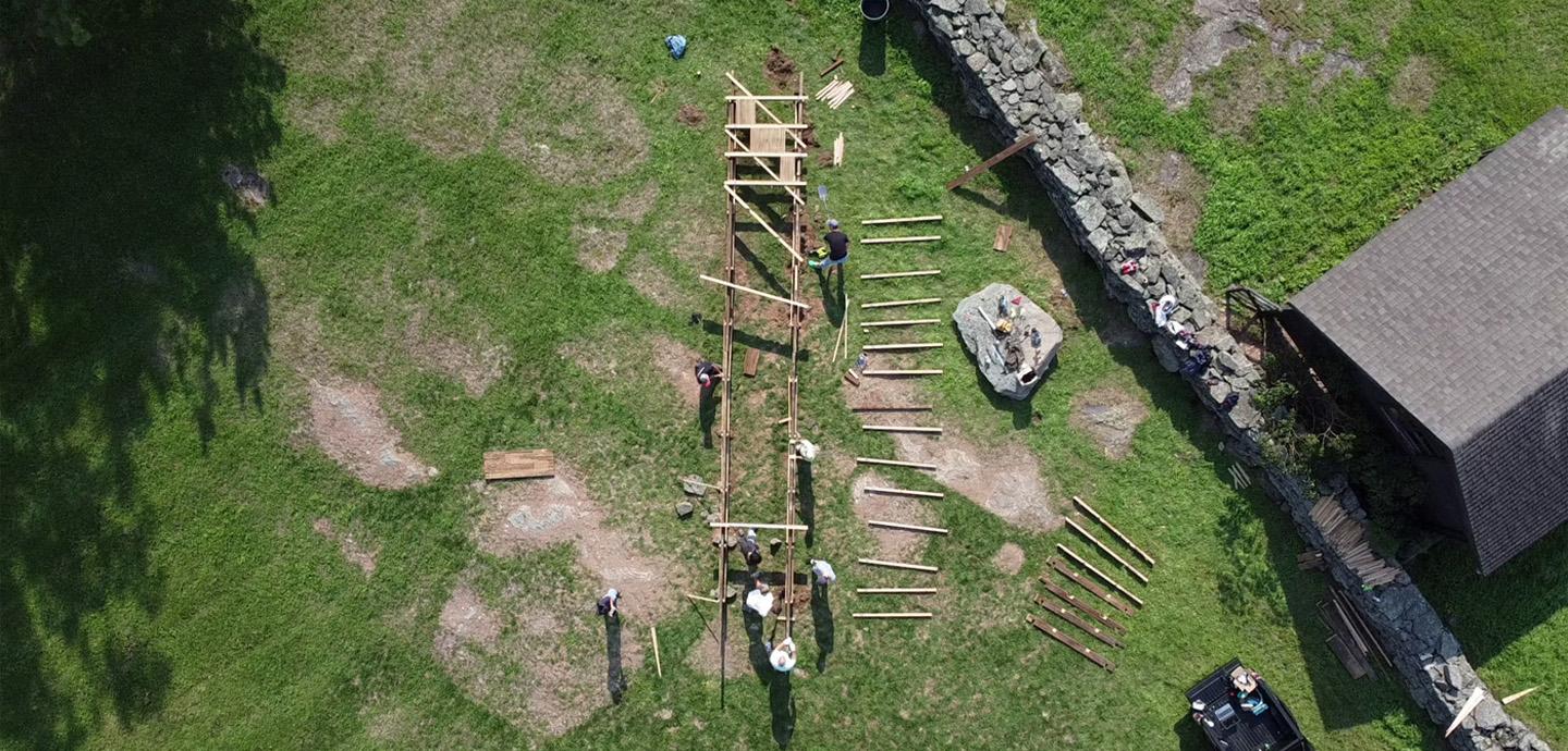 A top-view photo of the wooden boardwalk under construction over grass.