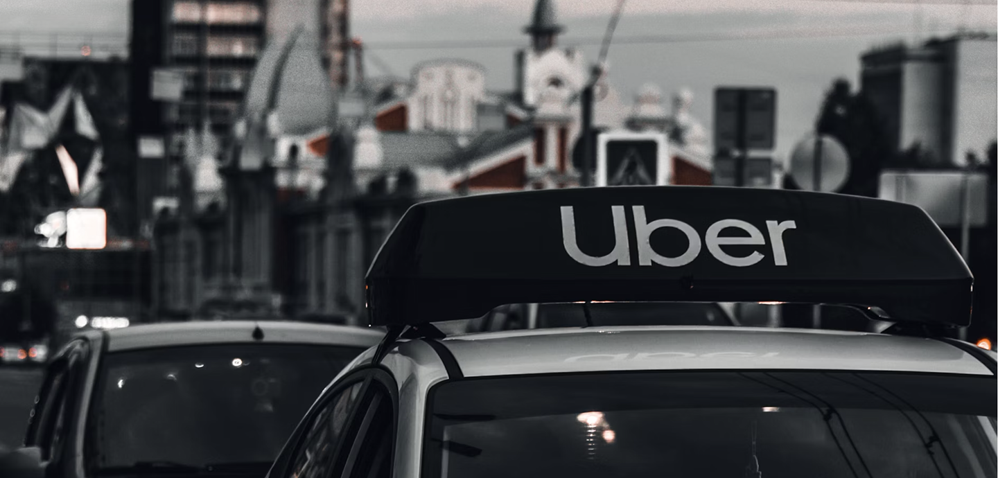 close up of car with an Uber sign in busy street and cityscape 