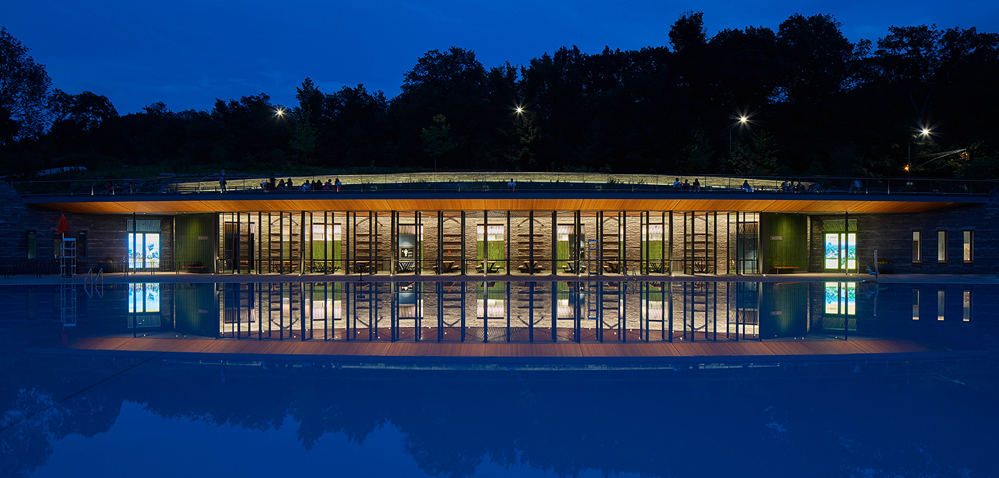 building set into a hillside with an infinity pool in front