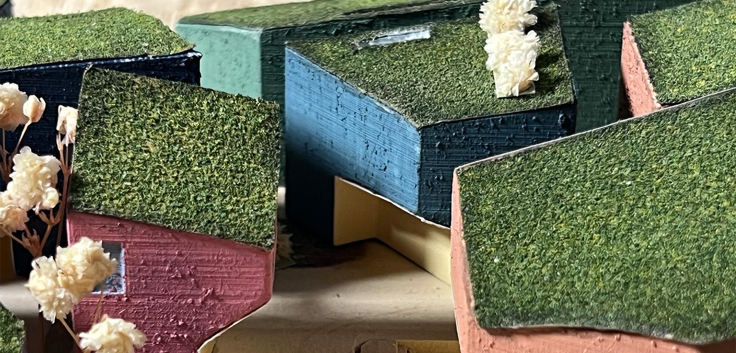 Photo of a colorful and textured model of various adjacent volumes.