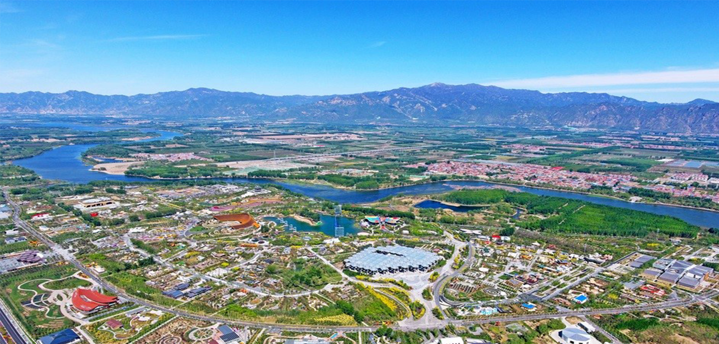 aerial photo of neighborhood with river and mountains in background