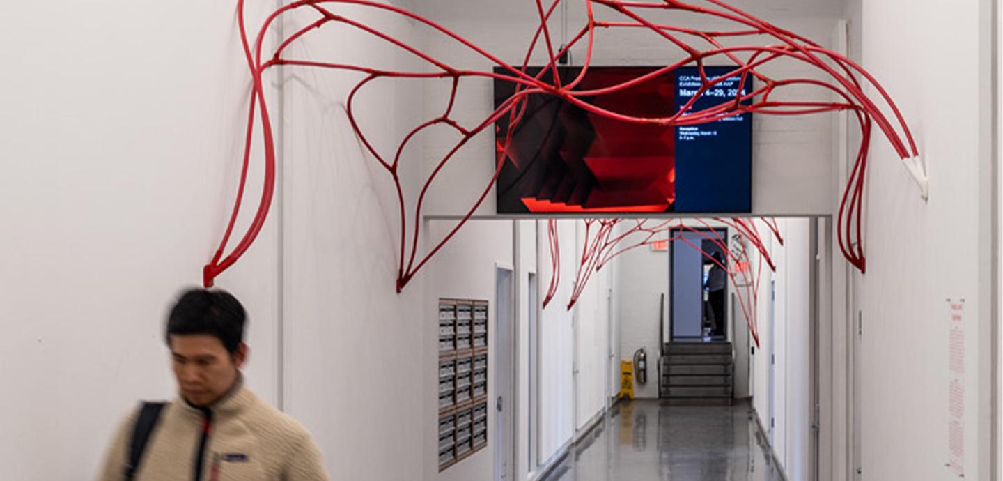 A man walks underneath the vault installation in the hallway.