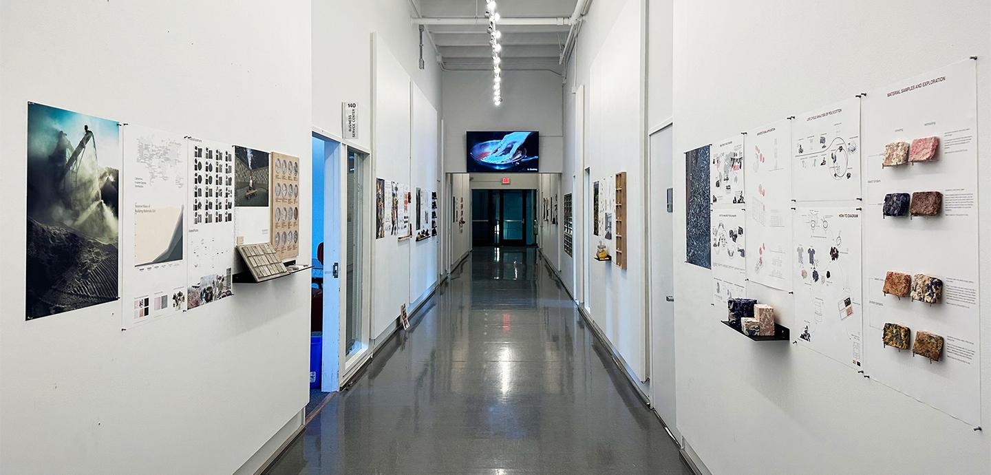 Exhibition hallway with material samples and images mounted on wall.