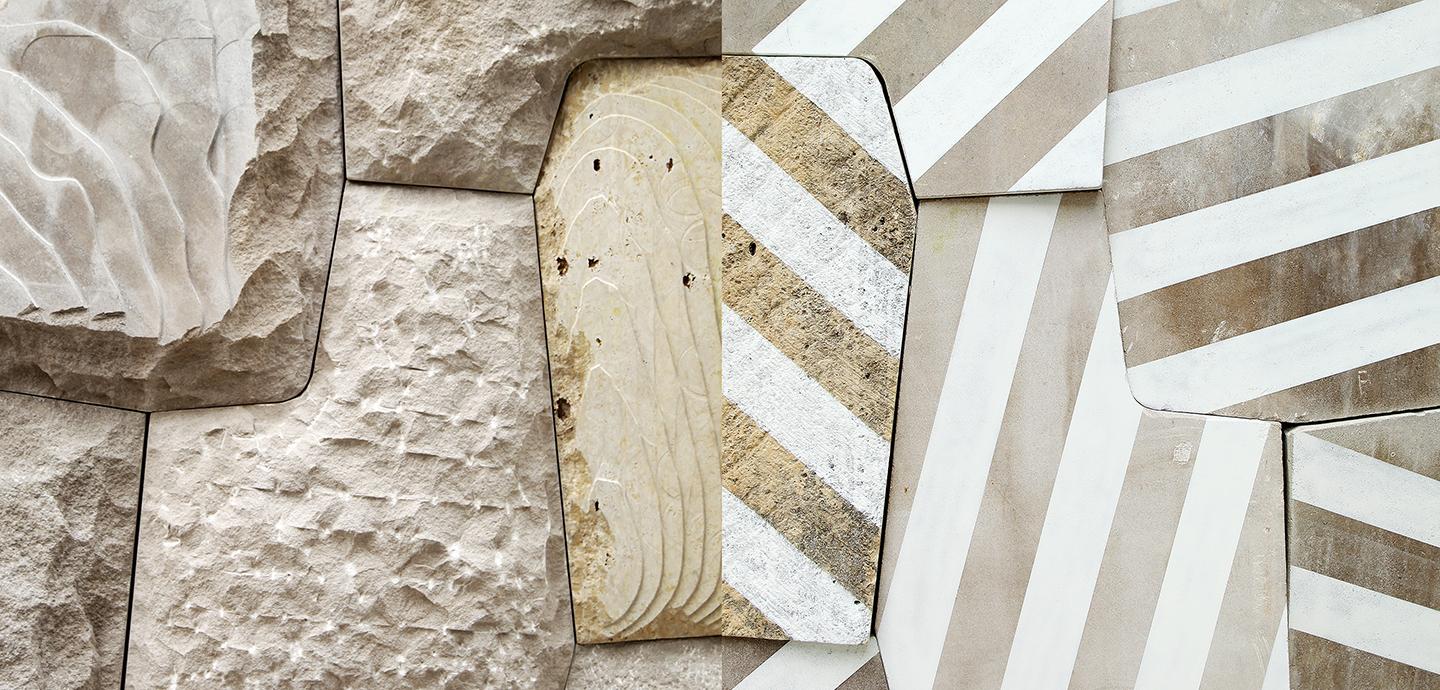 Light tan, textured stonework which alternates between unpainted stones, and stones which are covered in a series of both white and metallic gold stripes. 