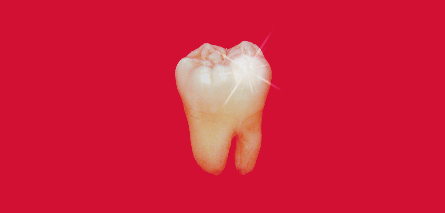 A photo of a sparkling tooth against a red background.