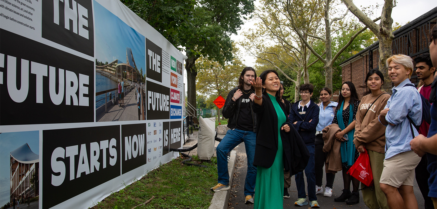 A group of people standing in front of a sign the reads 