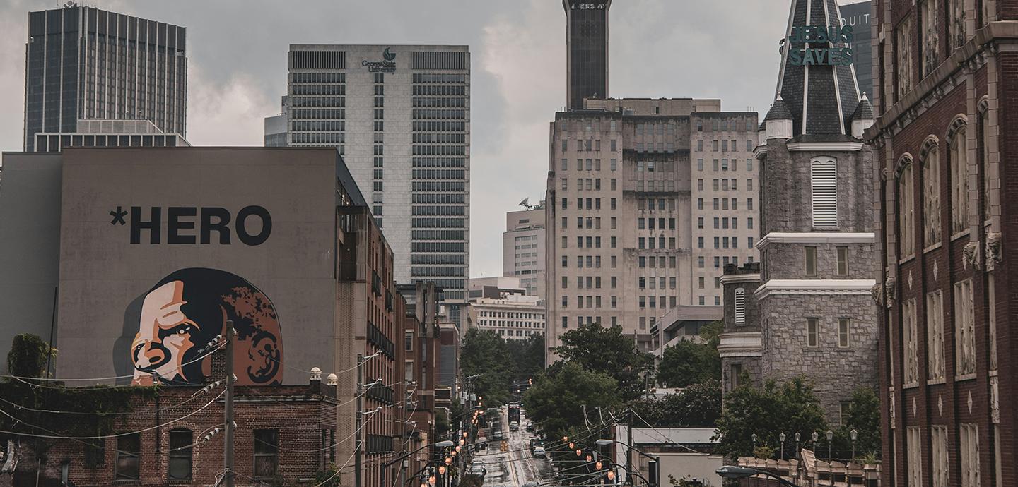 city view of Atlanta, Georgia featuring buildings, cars, street lights and a mural  