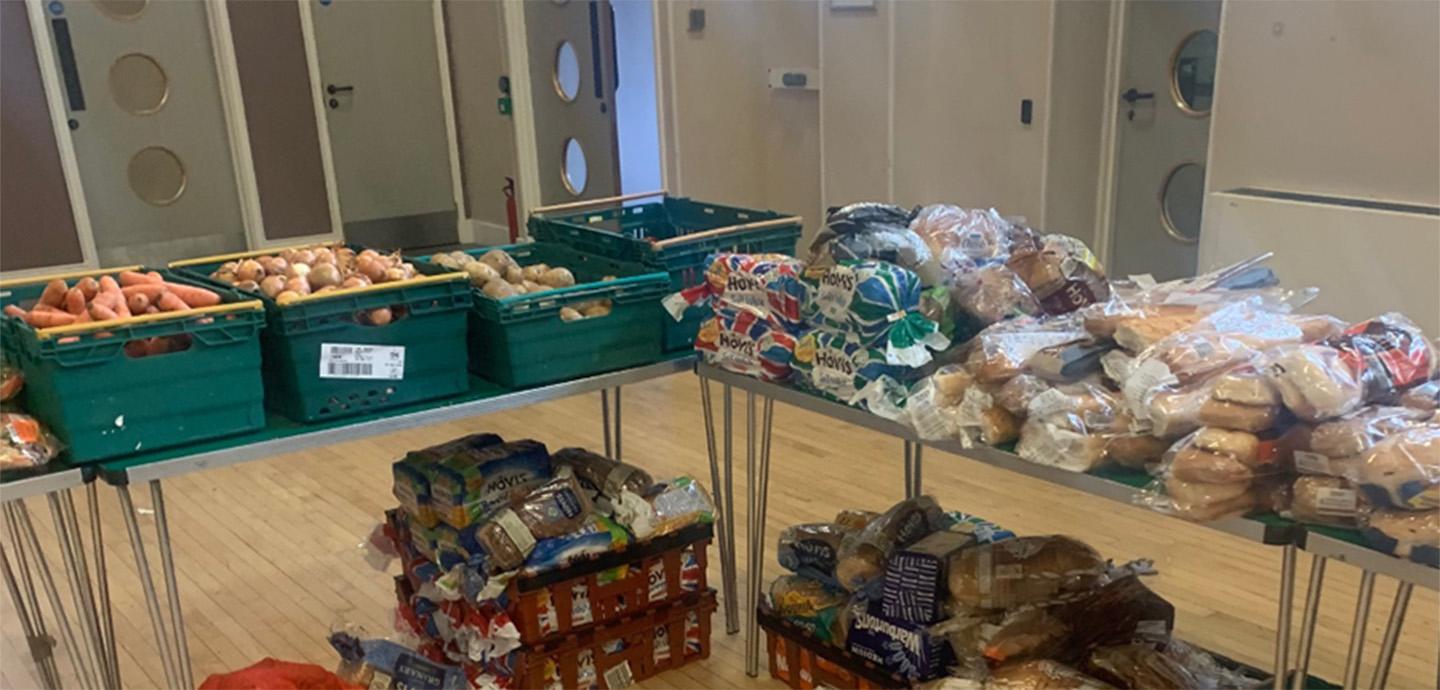 Folding tables piled high with bread in a room. 