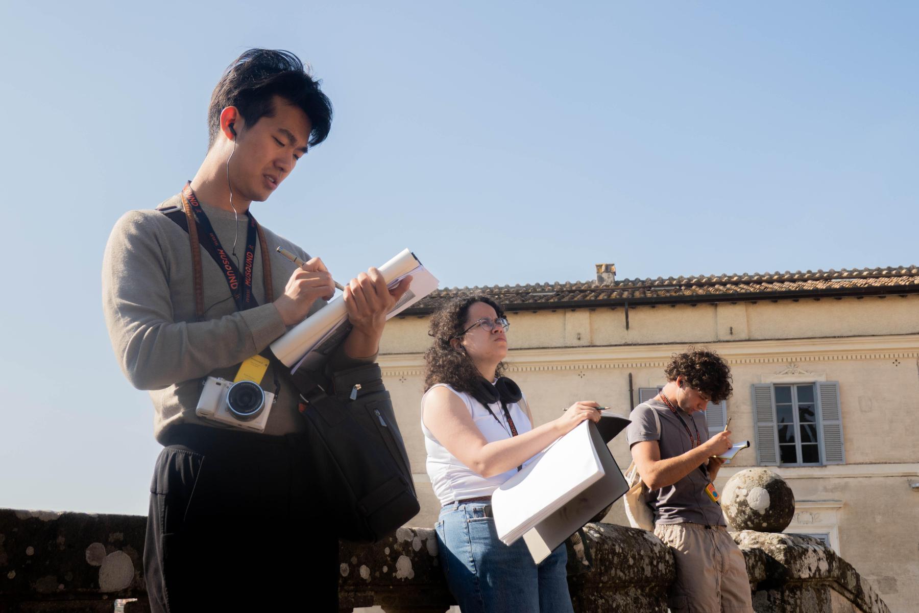 students outside in Italy drawing an historic building