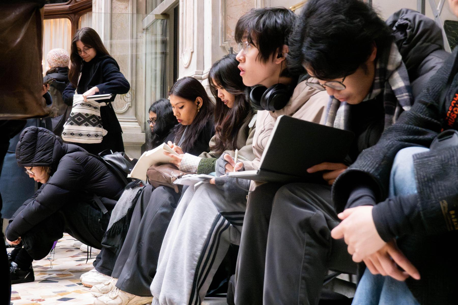 students sitting and drawing inside an italian historic building