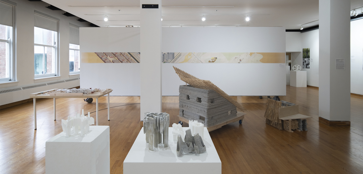 Student models created with concrete, plastic, straw, and wood, occupying the floor space of John Hartell Gallery