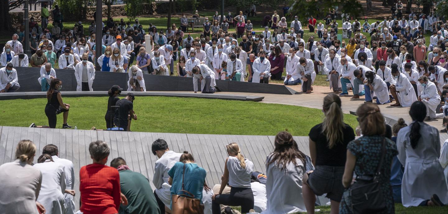 view of many people kneeling around a circular outdoor memorial