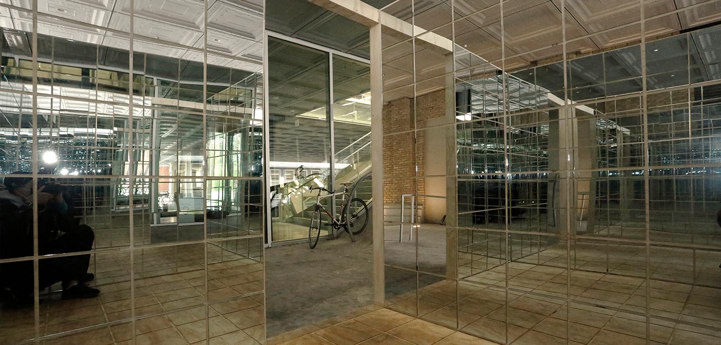 A view of a cube structure from within covered in mirrors.