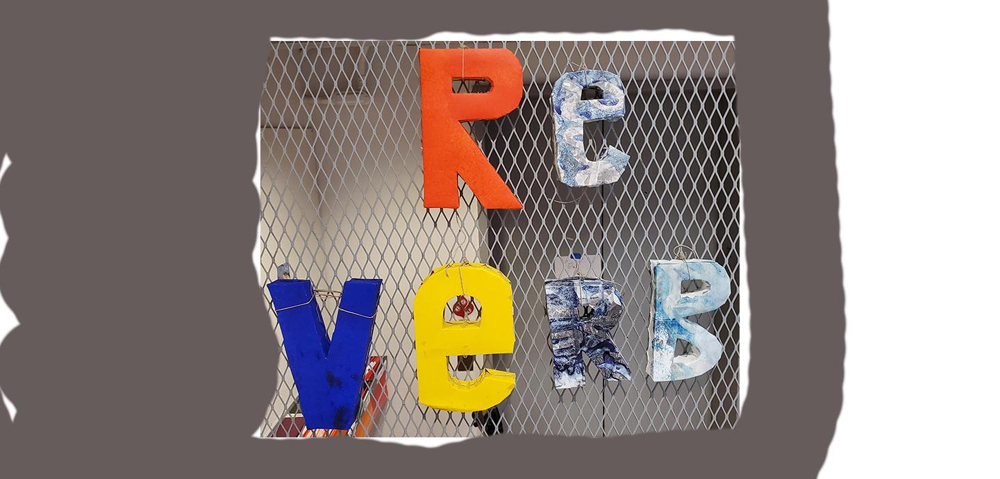 A metal grate with large 3D letters that spell out the word reverb