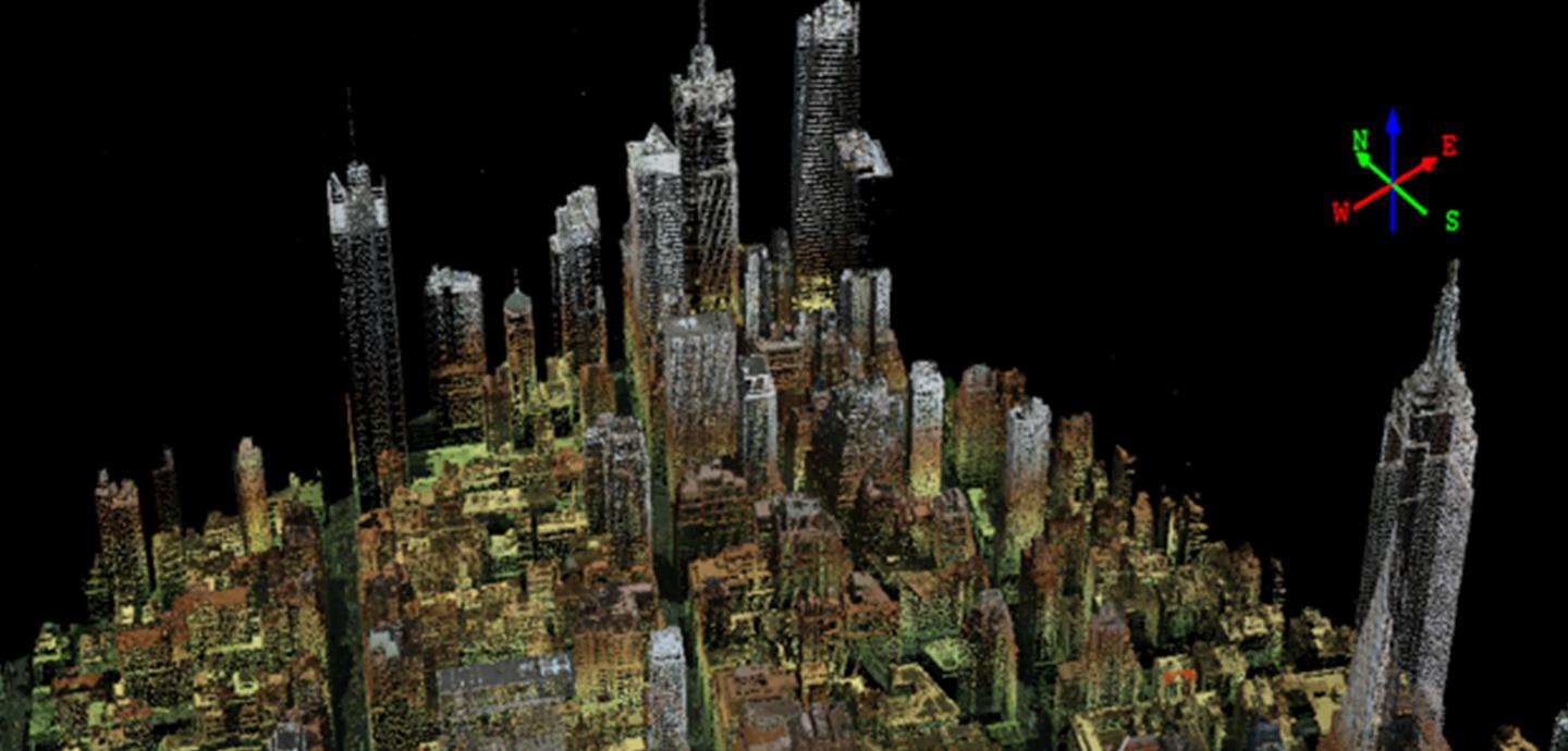 A digital representation of a city is seen from overhead on a black background, with a compass in the upper right corner of the image.