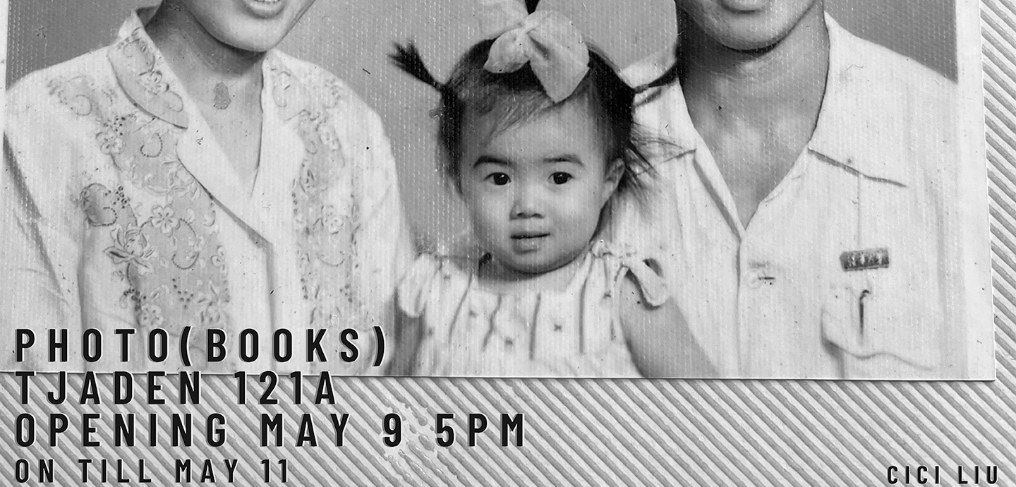 Black and white photo of a toddler with almond eyes, a white shirt, and black hair in pigtails with a bow. On either side of the child sit adults wearing white with their faces cut off from the chin up, with black text over it reading PHOTO (BOOKS) TJADEN 121A  OPENING MAY 9 5PM ON TILL MAY 11. 