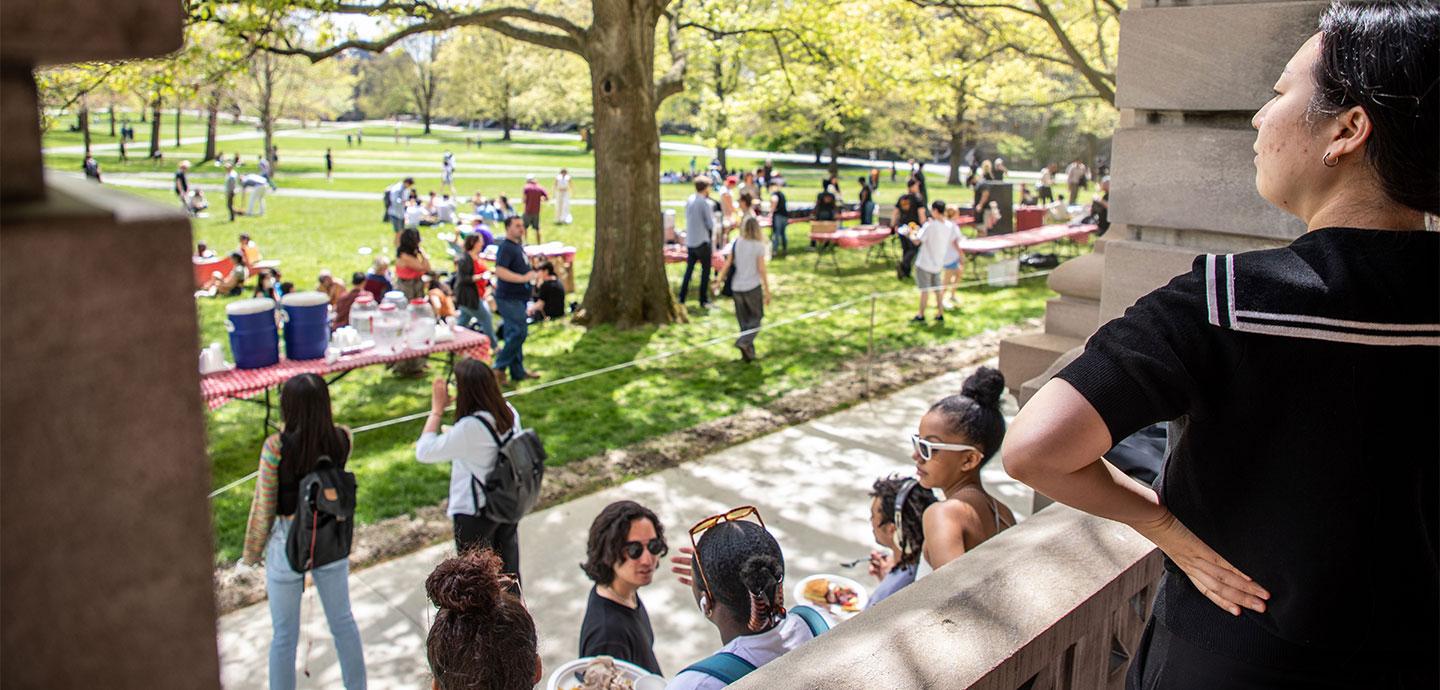 Group of people gathered on a lawn enjoying a picnic.