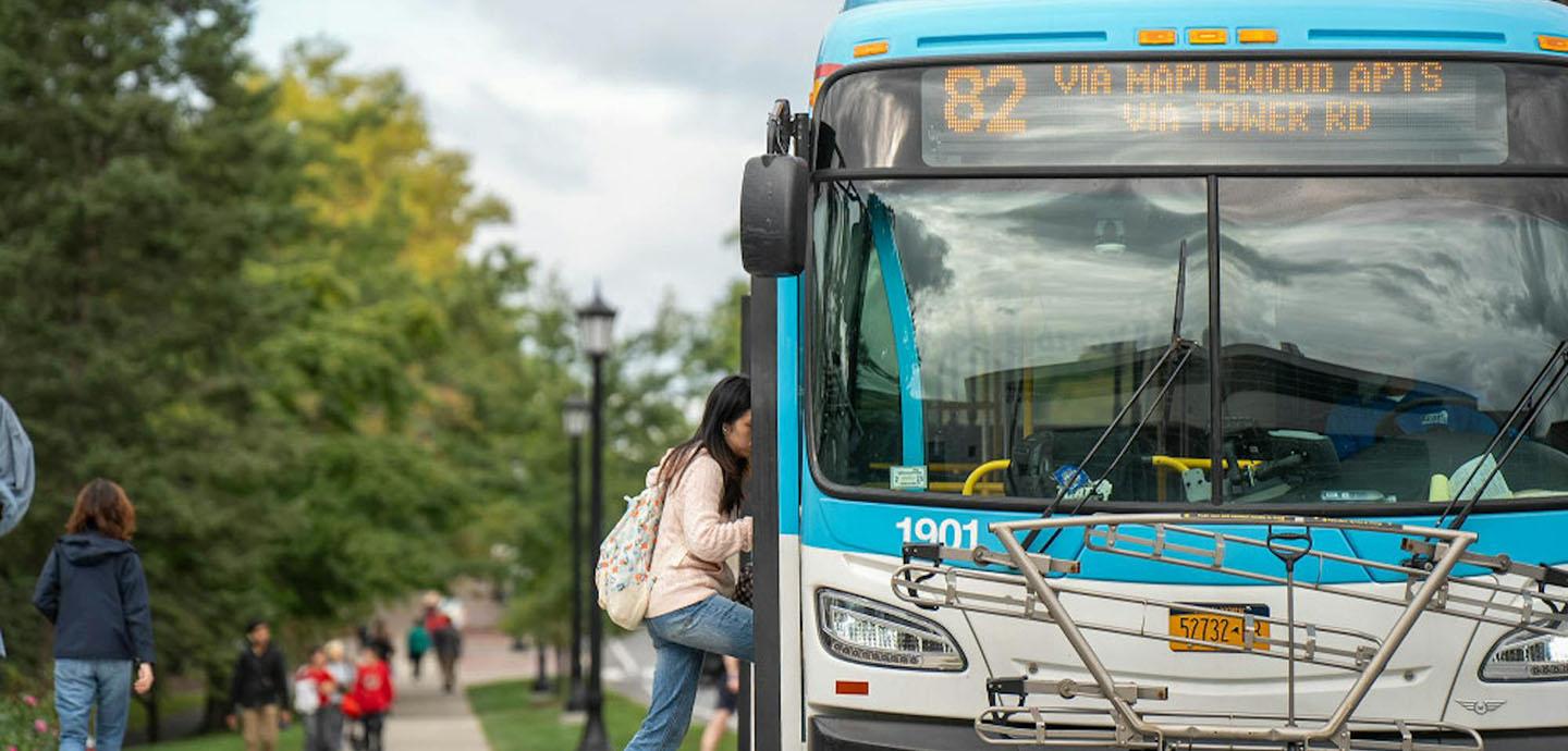 A student boarding a TCAT bus on campus