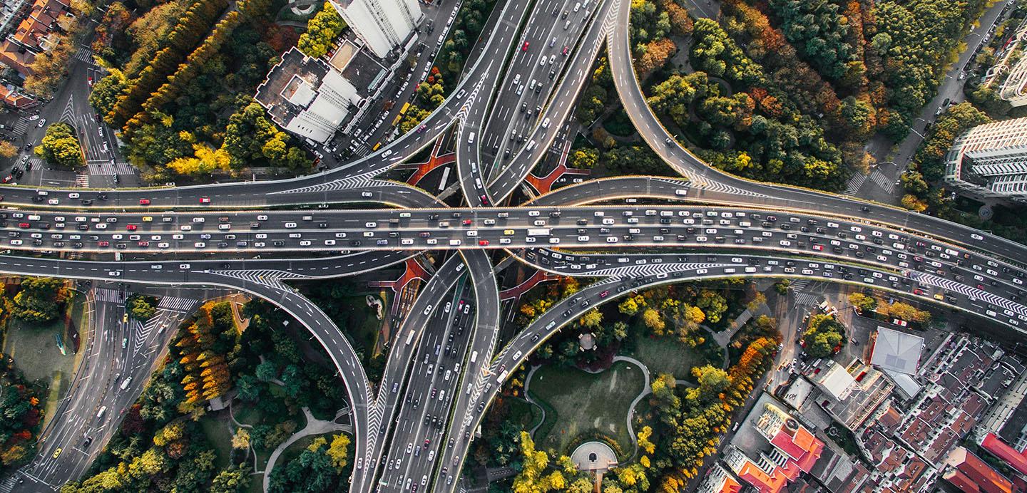 An aerial shot of a four way highway intersecting with other multi-lane highways