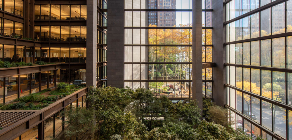 interior atrium of a city building with glass walls or windows and trees inside