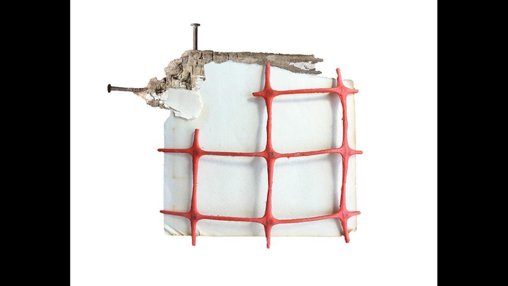 Abstract sculpture of a white square with red grid lines across it and two nails sticking out of the corner.