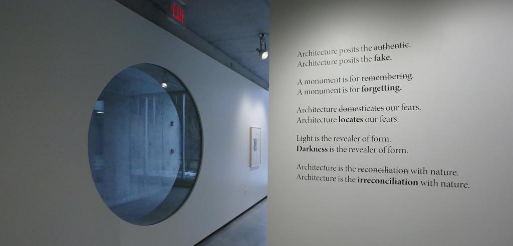 An oblique view of two art gallery walls with text on the right and a round window on the left.