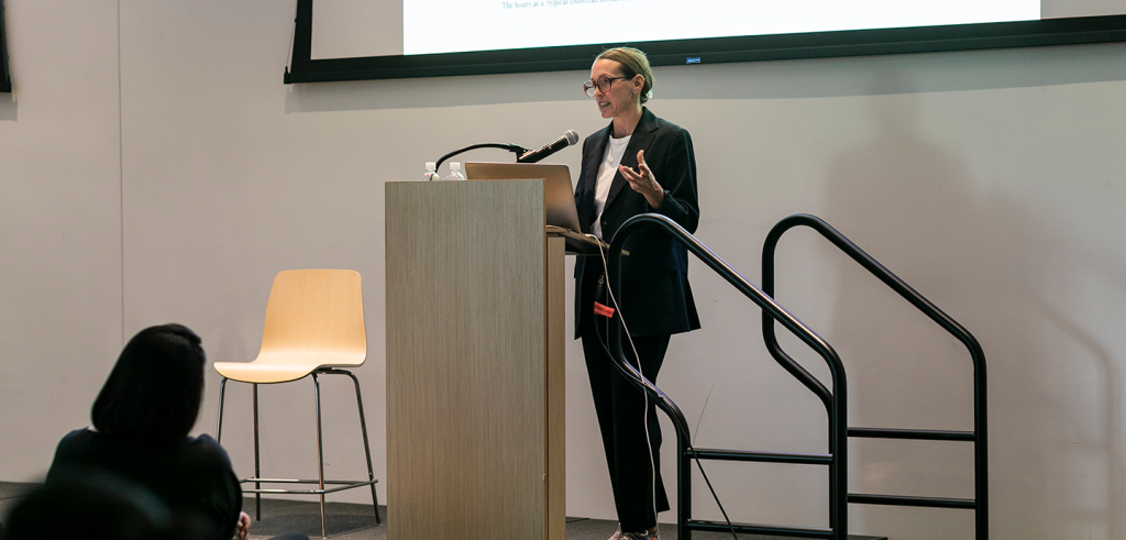 A person standing at a podium in front of a large crowd.