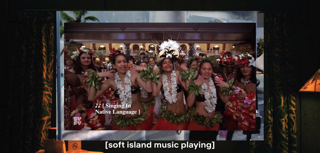 A movie still of hula dancers wearing floral leis and grass skirts, with subtitles that read, 