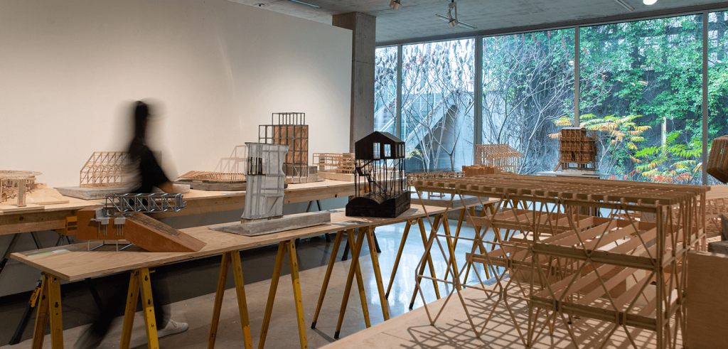 A person walking through a gallery of architectural models.