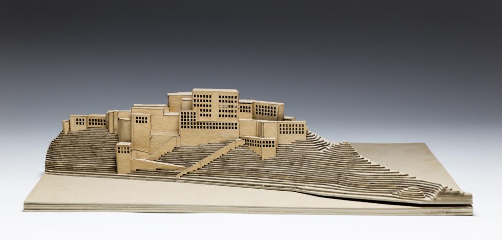 wooden model of a building set into some cliffs