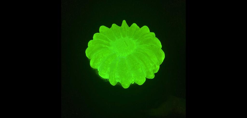 Bright green abstract sea creature on a black background.
