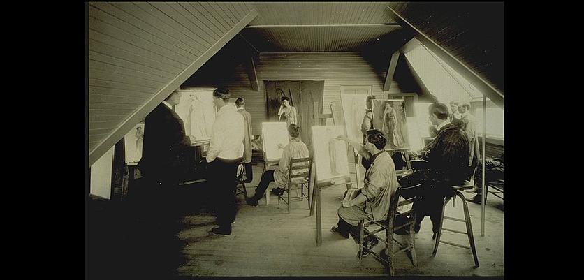 students drawing at easels facing a figure model