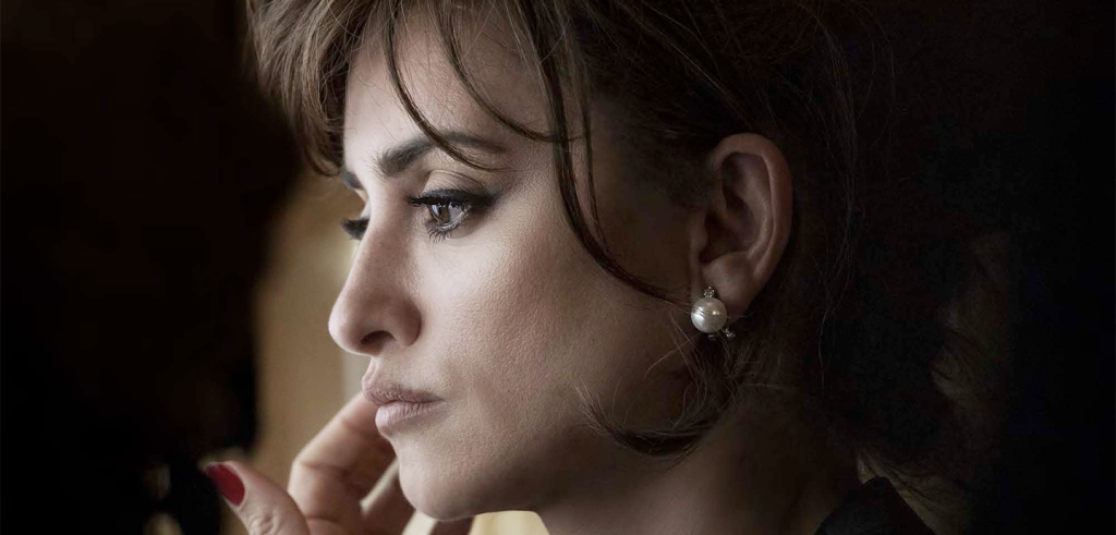 An image of a women with long dark hair and pearl earings.